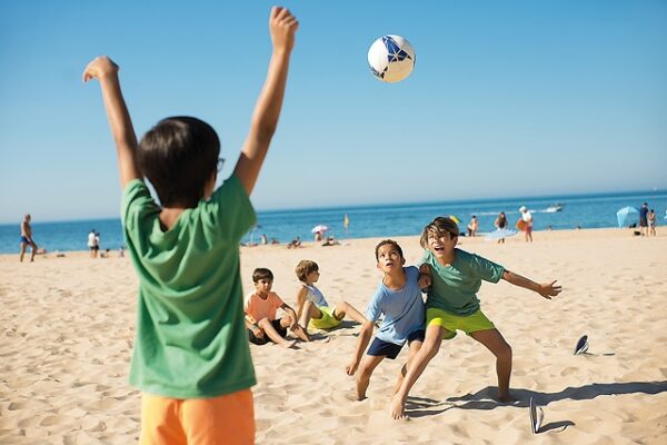 Enfant jouant au foot plage classe de mer languedoc