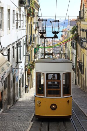 Tramway jaune de lisbonne dans la ville avec mer en arrière plan