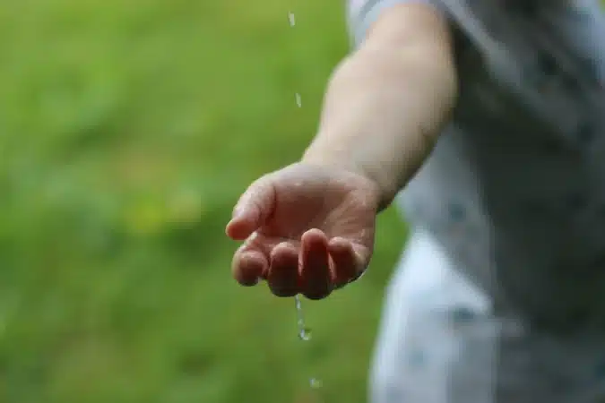 main d'enfant avec de l'eau qui coule nature et environnement